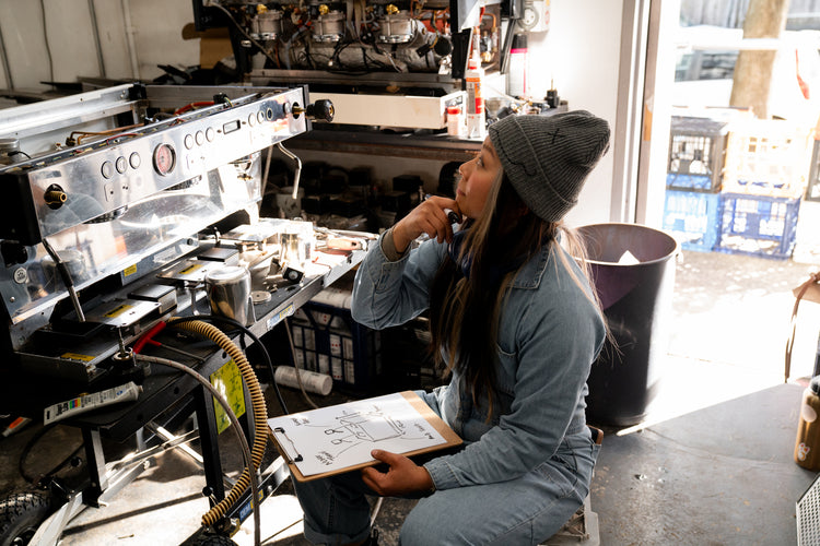 Person working on a coffee machine in a kitchen setting